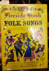Cover of the Fireside Book of Folk Songs with images of people dressed in "folk" dress, and flowers.