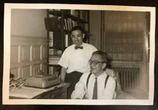 a chinese man standing with another man over a 1950s recorder