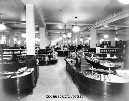 department store floor with illuminated globes hanging from the ceiling and merchandise counters